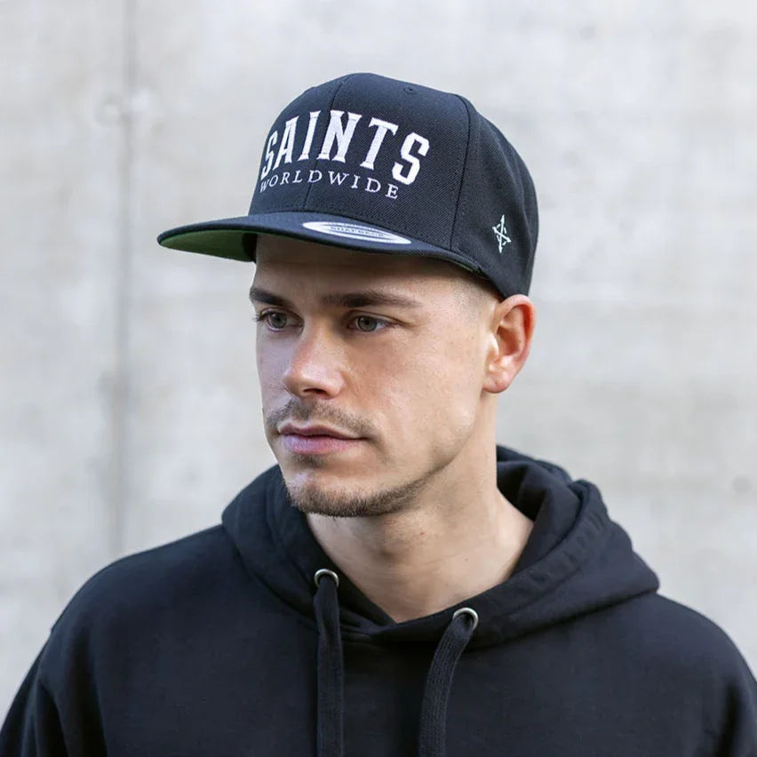 Model wearing SAINTS WORLDWIDE black snapback, front-facing close-up